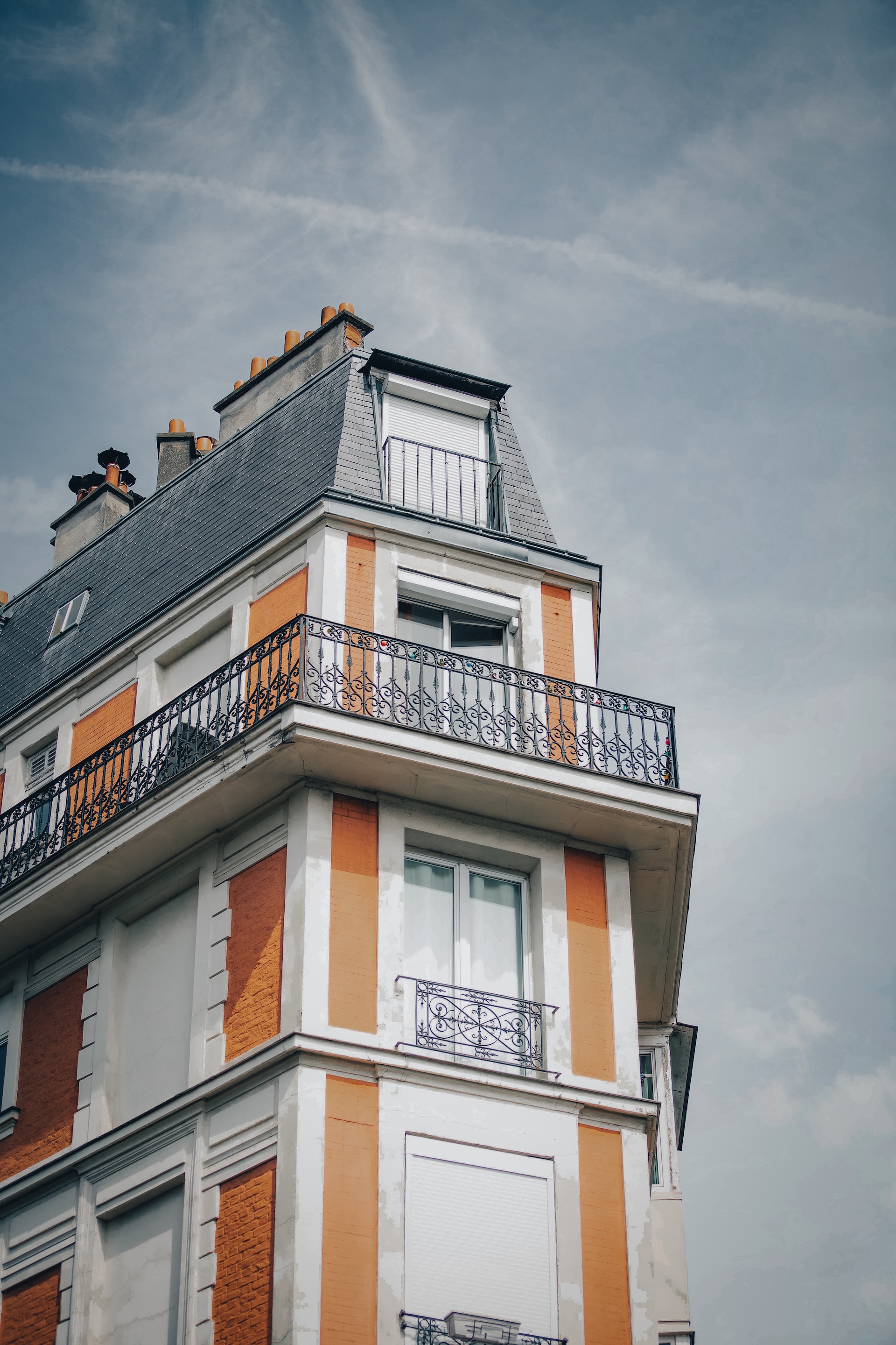 an orange and white building with a balcony and balconies